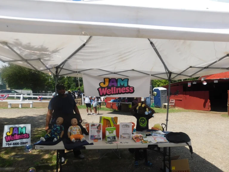 The JAM Wellness booth with CPR training manikins laid out for demonstrations