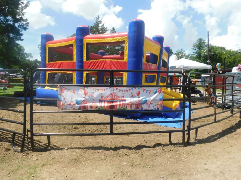The inflatable bounce house set up inside the fenced play area