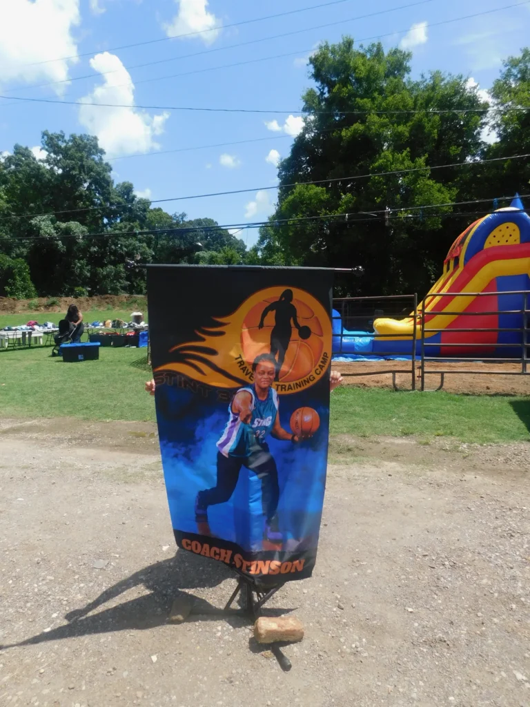 A Coach Stinson basketball training camp banner standing beside the inflatable slide