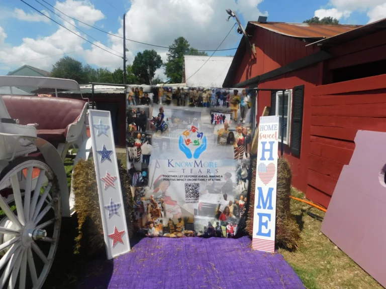 The Know More Tears photo backdrop and HOME SWEET HOME signs beside the white carriage