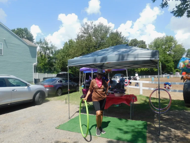 A volunteer sets up hula hoops at a games table