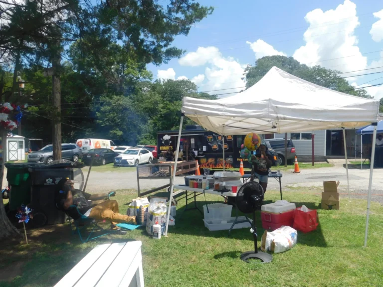A shaded seating area set up behind the vendor row