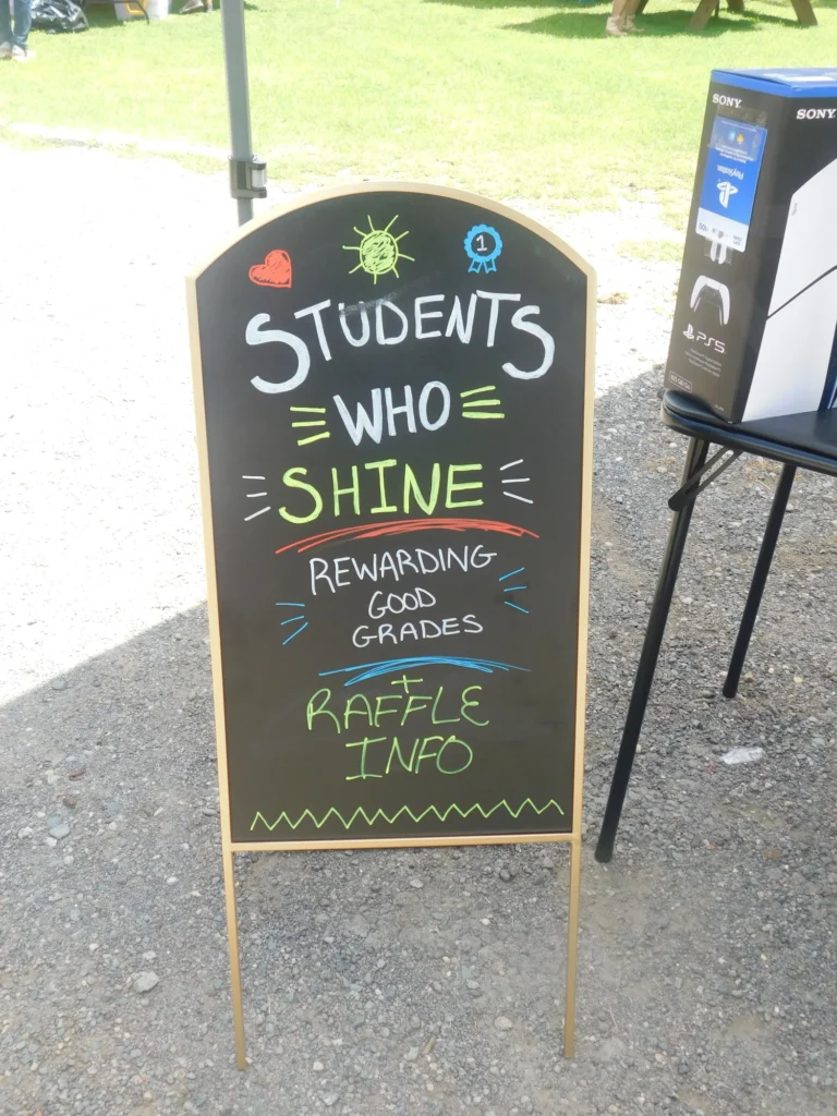 A Students Who Shine chalkboard sign advertising the good grades raffle