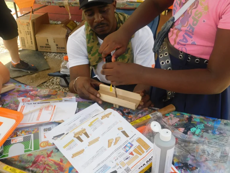 A volunteer assembles craft kits at the children's workshop table