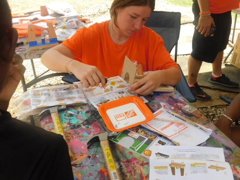 A Home Depot volunteer lays out a children's woodworking kit