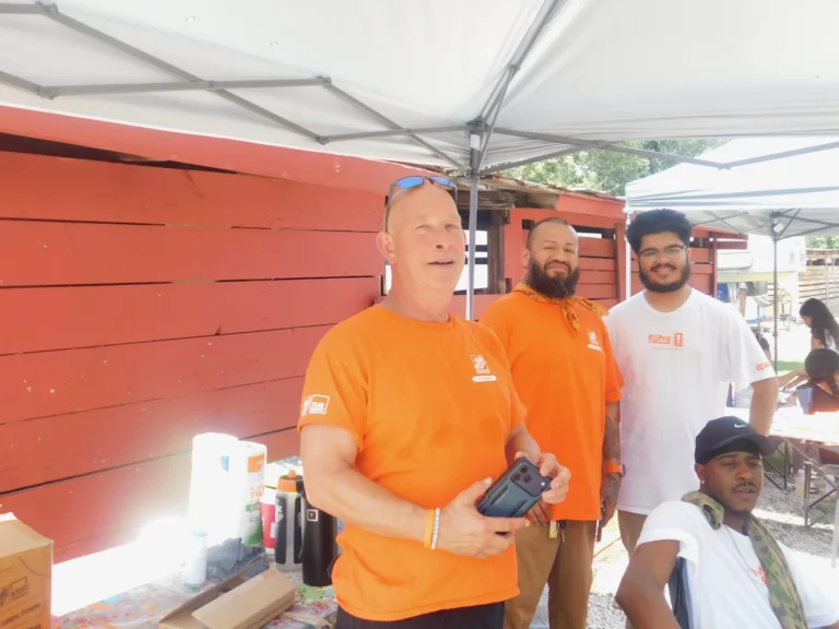 Home Depot volunteers gather beside the barn