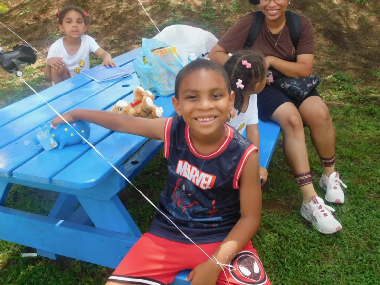 A young guest shows off a prize at the picnic tables