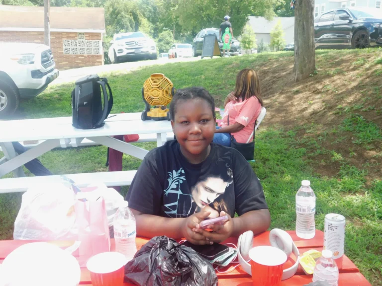 A young guest smiles at the table with her carnival prizes
