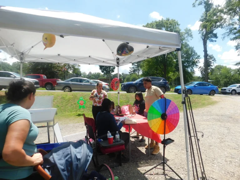 A volunteer runs the prize wheel for waiting families